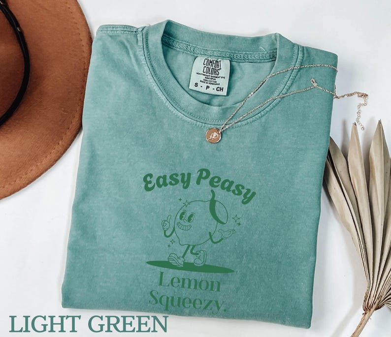 May include: Light green t-shirt with a green cartoon lemon character and the text "Easy Peasy Lemon Squeezy".