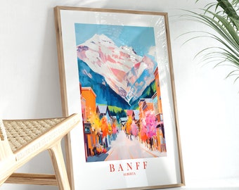 May include: A framed art print featuring a colorful street scene in Banff, Alberta. The artwork depicts a snow-capped mountain, buildings, and trees in vibrant hues of orange, pink, and blue. The word "BANFF" is printed in red at the bottom.