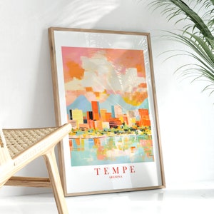 May include: A framed print of a colorful cityscape with a sunset sky. The city is outlined in orange, yellow, and blue, with a reflection of the city in the water below. The text "TEMPE ARIZONA" is printed at the bottom of the print.