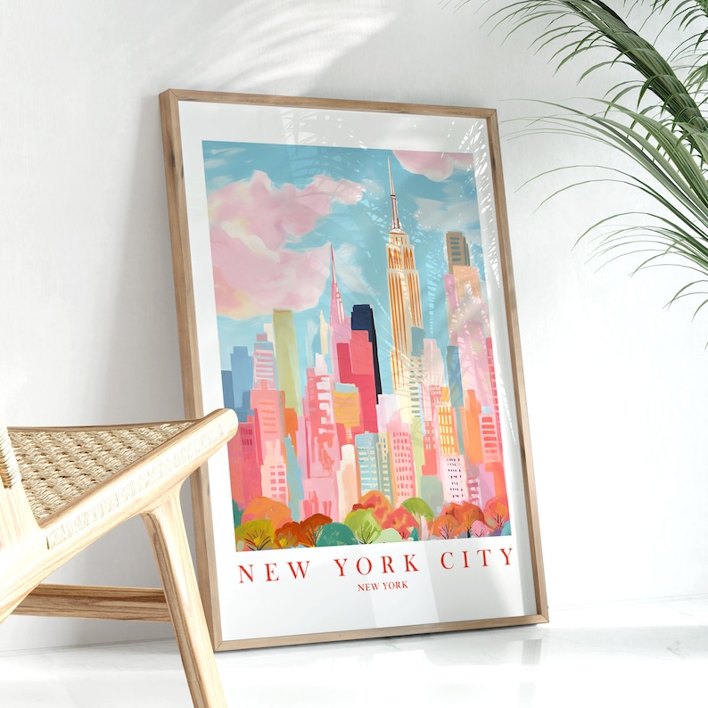 May include: A framed print of a colorful illustration of the New York City skyline with the Empire State Building in the center. The print has the text "NEW YORK CITY" and "NEW YORK" below the illustration.