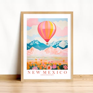 May include: A colorful hot air balloon floats over a pink and blue mountain range with a field of flowers in the foreground. The text "NEW MEXICO LAND OF ENCHANTMENT" is at the bottom of the image.