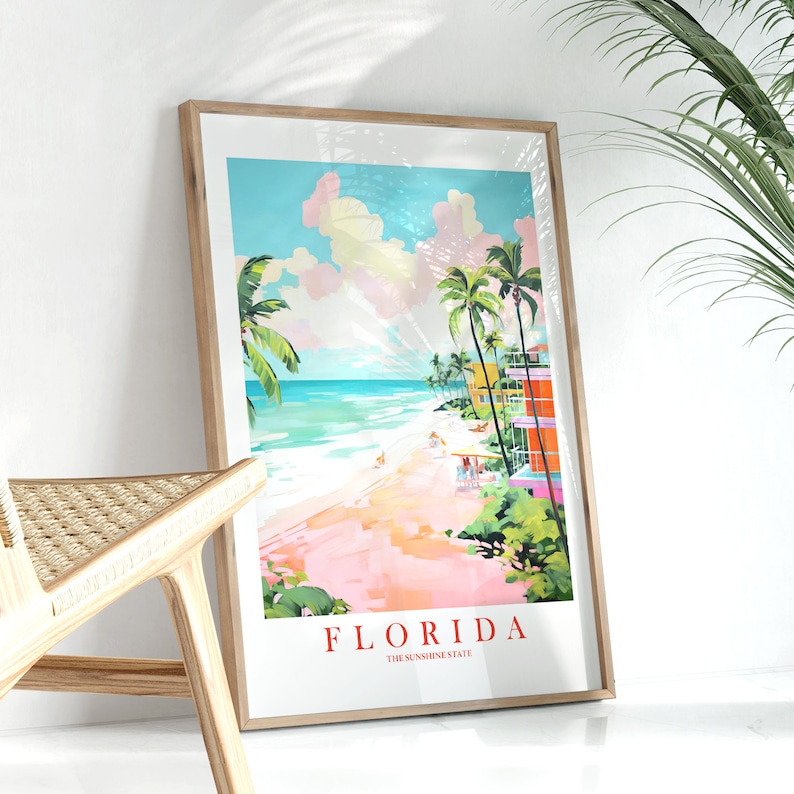 May include: A framed poster with a colorful illustration of a beach scene in Florida. The poster features palm trees, a beach, and buildings in bright colors. The text "FLORIDA THE SUNSHINE STATE" is at the bottom of the poster.