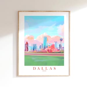 May include: A framed art print of the Dallas, Texas skyline. The artwork features a colorful, impressionistic style with a blue sky, pink clouds, and a green foreground. The word "DALLAS" is printed in red at the bottom.