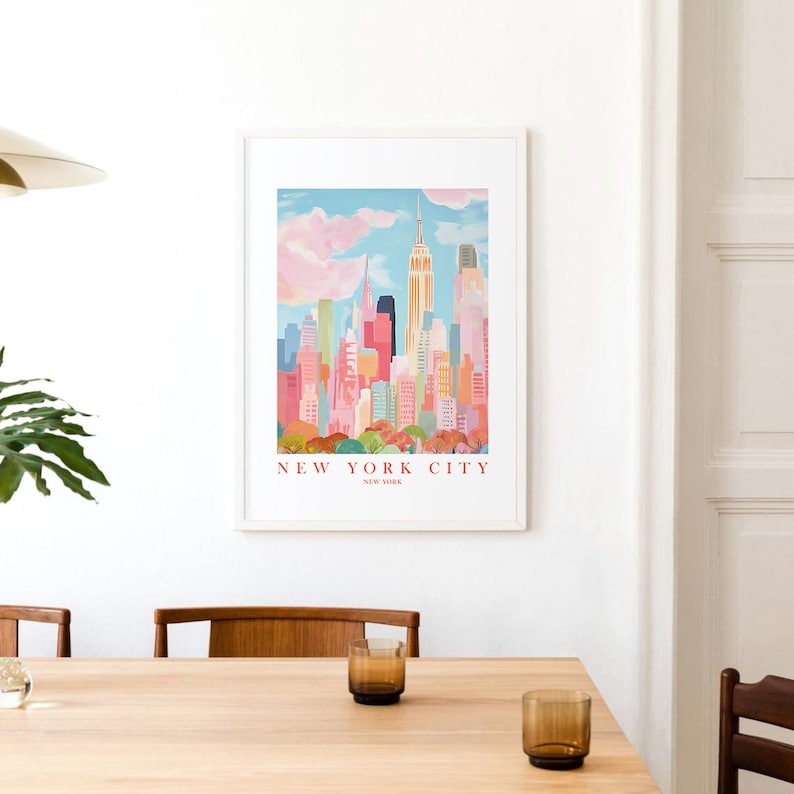 May include: A framed print of a colorful illustration of the New York City skyline with the Empire State Building in the center. The text "NEW YORK CITY" is printed below the image.