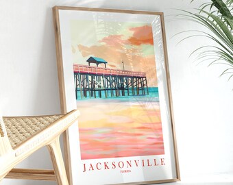 May include: A framed print of a watercolor painting of a pier with a wooden structure and a blue roof. The pier is over a body of water with a pink and orange sunset in the background. The text "JACKSONVILLE FLORIDA" is at the bottom of the print.