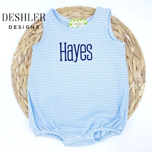 May include: A light blue and white striped baby onesie with a navy blue embroidered name "Hayes".