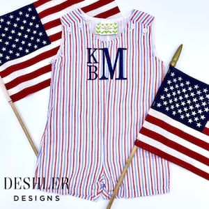 May include: Red, white, and blue striped baby romper with a navy blue monogram "KBM" on the front. The romper is made of a lightweight fabric and has a sleeveless design.