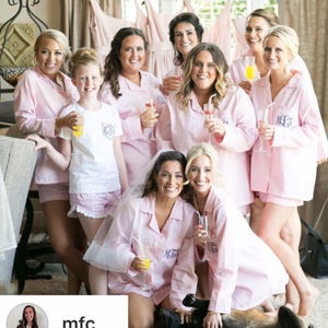 Puede incluir: Un grupo de mujeres en pijama rosa con bordados de monogramas a juego. Est&aacute;n sosteniendo copas de champ&aacute;n y sonriendo. Las mujeres est&aacute;n reunidas en una habitaci&oacute;n con un fondo blanco. El texto "mfc_" es visible en la esquina inferior izquierda de la imagen.