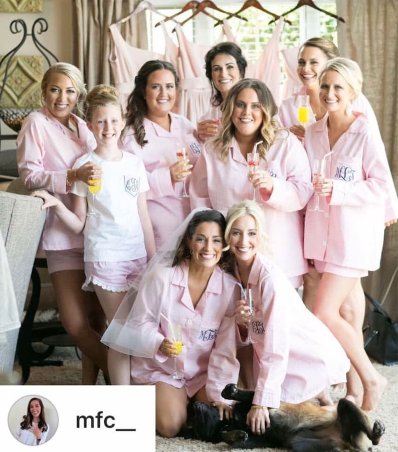 Puede incluir: Un grupo de mujeres en pijama rosa con bordados de monogramas a juego. Est&aacute;n sosteniendo copas de champ&aacute;n y sonriendo. Las mujeres est&aacute;n reunidas en una habitaci&oacute;n con un fondo blanco. El texto "mfc_" es visible en la esquina inferior izquierda de la imagen.
