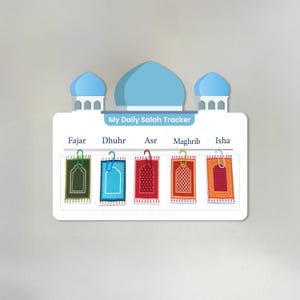 May include: A white rectangular daily Salah tracker board featuring a blue mosque dome illustration at the top. The text My Daily Salah Tracker is printed below the domes. Five prayer names are listed with colorful prayer rug cards attached.