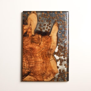 Könnte beinhalten: Ein rechteckiges Holzkunstwerk mit einem Abschnitt eines Baumstamms mit sichtbarer Maserung und Textur. Das Holz hat eine warme braune Farbe und ist in einem klaren Harz mit eingebetteten Kaffeebohnen eingeschlossen. Das Harz hat einen silbergrauen Farbton.