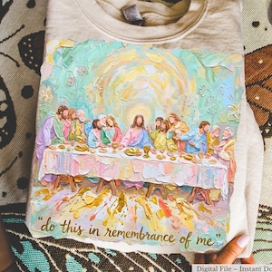 Może przedstawiać: Beżowa bluza z okrągłym dekoltem z kolorowym, impresjonistycznym obrazem Ostatniej Wieczerzy. Grafika przedstawia postacie siedzące przy stole z napisem "do this in remembrance of me".