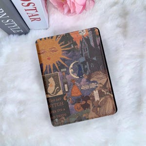 May include: A rectangular case with a vintage Halloween design. The artwork features a sun with a face, a haunted house, a cat, and the text "You say witch like it's a bad thing."