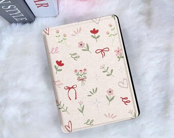 May include: A cream-colored tablet case featuring a floral pattern with red and pink flowers, green leaves, and red bows. The case has a black border and is set against a white, fluffy background.