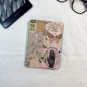 Può includere: Una custodia decorativa per Kindle con un design a collage. La custodia presenta uno scheletro, farfalle, un sole e il testo che dice "It's All Right" e "You Are Allowed To Do Things Differently". La tavolozza dei colori include rosa, beige e verde.