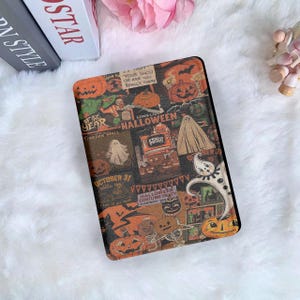 Może przedstawiać: Prostokątne etui o tematyce Halloween z kolażem grafik w stylu vintage. Projekt zawiera dynie, duchy i tekst, taki jak "Halloween" i "October 31". Etui jest umieszczone na białym, puszystym tle.