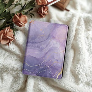 Könnte beinhalten: E-Reader-Hülle mit Marmormuster in Lila und Gold, schwarzer Rand.