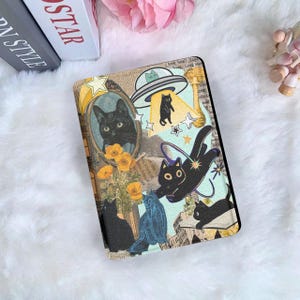 Può includere: Una custodia decorativa per tablet con un collage di gatti neri, fiori gialli e ritagli di giornali vintage. Il design include un ritratto di gatto, un UFO con un gatto e altre illustrazioni di gatti giocosi. La custodia ha un tocco morbido e strutturato.