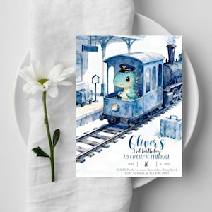 Puede incluir: Una tarjeta de invitación de cumpleaños rectangular con una ilustración en acuarela de un tren azul sobre vías con un dinosaurio de dibujos animados con gorra de conductor. El texto dice Oliver's 3rd Birthday, April 16, 6-8PM, 12345 Park Avenue, Brooklyn, New York.