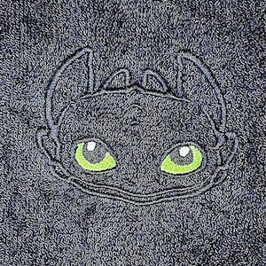 May include: Black and green embroidered design of a dragon's face on a dark blue towel.