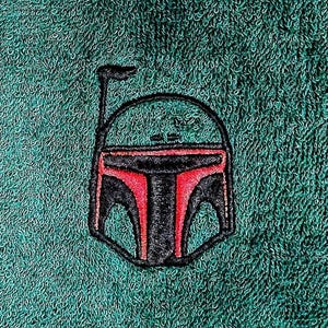 May include: A green towel with an embroidered image of a black and red Star Wars character helmet.