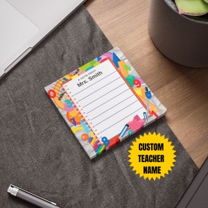 May include: A notepad with a colourful design featuring school supplies such as pencils, rulers, and protractors. The notepad has a lined page with the text "A note from Mrs. Smith".
