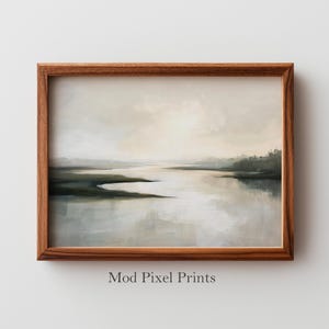 Könnte beinhalten: Ein gerahmter Landschaftsdruck mit einer ruhigen Wasserlandschaft in gedämpften Tönen von Beige, Grau und Grün. Das Kunstwerk ist in einem warmbraunen Holzrahmen eingefasst. Der Text "Mod Pixel Prints" ist unten im Bild aufgedruckt.