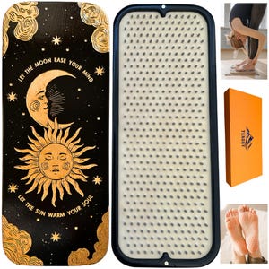 Op de afbeelding: Een houten acupressuurmat met een zwarte achtergrond en een gouden ontwerp. De mat heeft een halve maan en een zon met de tekst "Let the moon ease your mind" en "Let the sun warm your soul". De mat wordt getoond met een zwart frame en een wit acupressuuroppervlak. De mat wordt ook getoond in een doos met de merknaam "Tengry".