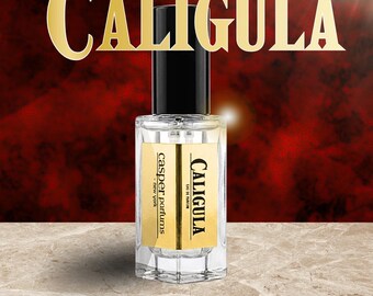 May include: A clear glass perfume bottle with a black cylindrical cap. The label features a gold rectangular background with black text reading CALIGULA, EAU DE PARFUM, and casper parfums - new york. The word CALIGULA is also displayed in large gold letters.