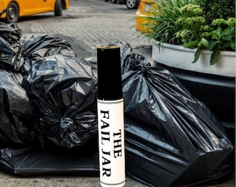 May include: A cylindrical product labeled "THE FAIL JAR" stands upright against a backdrop of black trash bags and a city street scene. The product has a black top and a white body with black text. The background includes yellow taxis and parked cars.