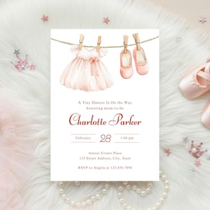 May include: A baby shower invitation featuring a watercolor illustration of a pink dress and ballet shoes hanging on a clothesline. The invitation includes the text "A Tiny Dancer Is On the Way" and details for Charlotte Parker's baby shower.
