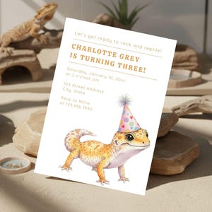 May include: A birthday invitation featuring a watercolor illustration of a gecko wearing a party hat. The invitation reads "CHARLOTTE GREY IS TURNING THREE!" with event details. The background includes a real lizard and decorative elements.