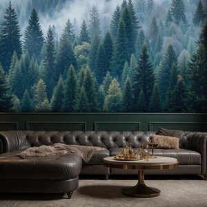 May include: A living room with a forest mural, a dark gray leather sectional sofa, and a round coffee table. The room is decorated with a floor lamp, a side table, and a rug. The overall theme is nature and luxury.
