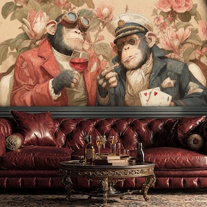 Puede incluir: Una escena interior artística con un sofá de cuero burdeos capitoné, una mesa de centro redonda y una pintura enmarcada de dos monos con ropa vintage. La pintura representa a los monos con vino y naipes.