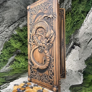 May include: A wooden backgammon board with a detailed dragon carving. The board is open, revealing the playing surface, and includes a set of game pieces in various colors. The dragon carving is intricately detailed.