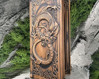 May include: A rectangular wooden backgammon board featuring a detailed relief carving of a dragon on its exterior. The board is standing upright, accompanied by a collection of small, round, tan and dark gray game pieces scattered at its base.