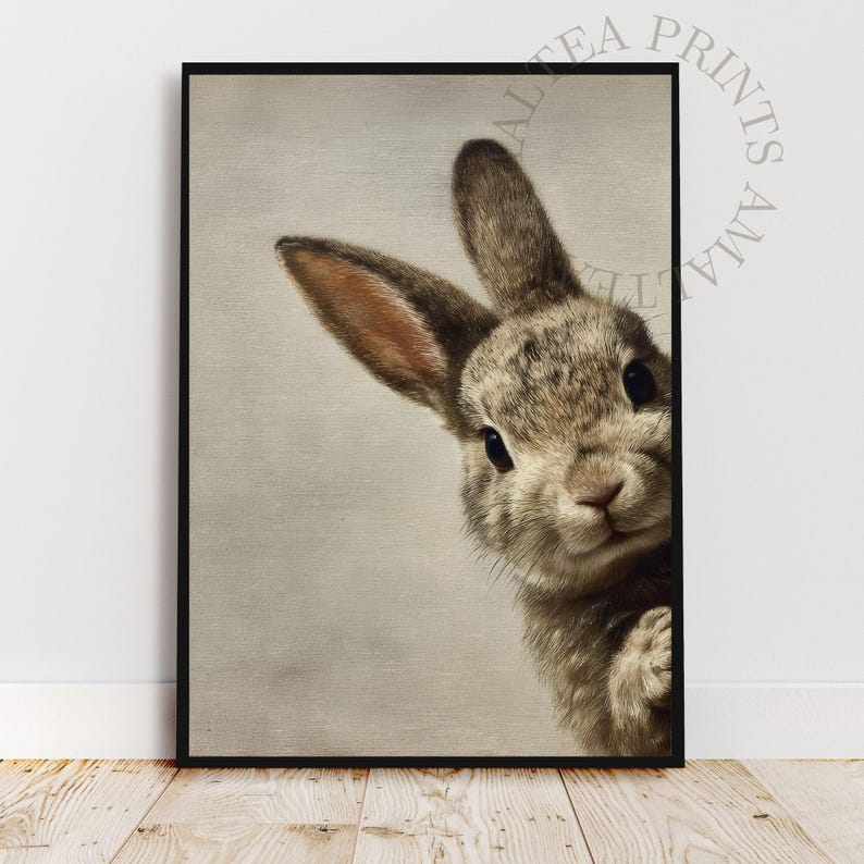 May include: A framed print featuring a detailed illustration of a rabbit peeking from the side. The rabbit has brown and gray fur, with long ears and dark eyes. The artwork is set against a neutral background.