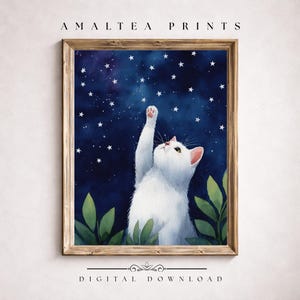 Könnte beinhalten: Ein gerahmter Druck mit einer weißen Katze, die nach Sternen in einem dunkelblauen Nachthimmel greift. Die Katze hat rosa Ohren und Pfoten, mit grünen Blättern am unteren Rand. Der Text "AMALTEA PRINTS" und "DIGITAL DOWNLOAD" befinden sich oben und unten.