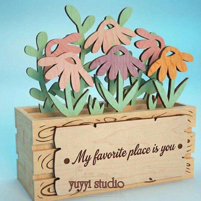 Peut inclure: Bo&icirc;te &agrave; fleurs en bois avec des fleurs d&eacute;coup&eacute;es au laser dans des tons de rose, orange et violet. La bo&icirc;te porte une enseigne d&eacute;corative en bois avec l'inscription "My favorite place is you" et le logo "yuyyi studio".