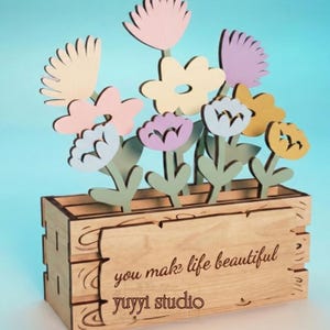 Peut inclure: Bo&icirc;te &agrave; fleurs en bois avec des fleurs d&eacute;coup&eacute;es au laser aux couleurs pastel. Les fleurs sont roses, jaunes, violettes et blanches. La bo&icirc;te porte l'inscription "you make life beautiful" et "yuyyi studio".