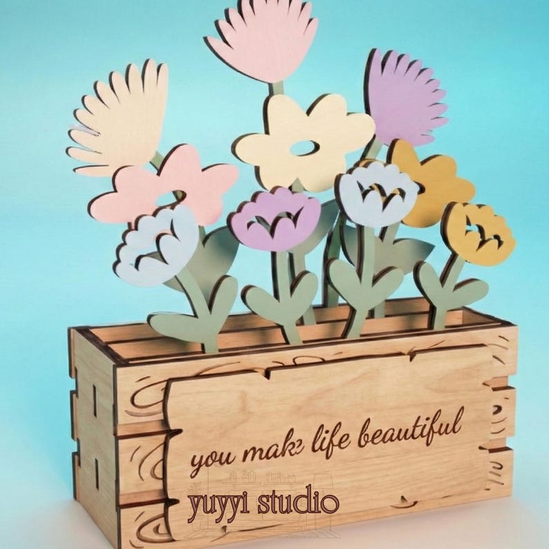 Peut inclure: Bo&icirc;te &agrave; fleurs en bois avec des fleurs d&eacute;coup&eacute;es au laser aux couleurs pastel. Les fleurs sont roses, jaunes, violettes et blanches. La bo&icirc;te porte l'inscription "you make life beautiful" et "yuyyi studio".