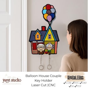 May include: A colorful wooden key holder featuring a house design with a balloon cluster. The key holder depicts an elderly couple and includes the text "Balloon House Couple Key Holder". The key holder is mounted on a white wall.