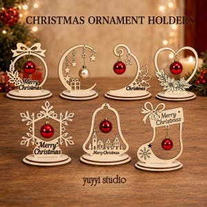 Puede incluir: Siete soportes de madera clara para adornos navideños con bases circulares. Los diseños incluyen un lazo, una luna creciente con estrellas, un remolino, un corazón con flor de pascua, un copo de nieve, una campana con pueblo y un calcetín.