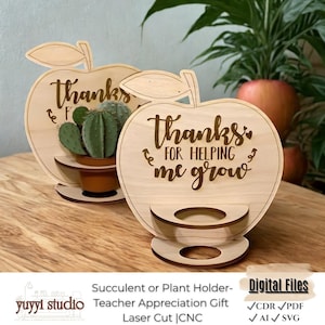 May include: Wooden apple-shaped succulent holders with the text "Thanks for helping me grow." One holder displays a small cactus in a brown pot. The holders are laser cut and designed as a teacher appreciation gift.