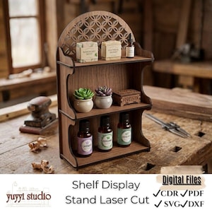 Puede incluir: Una estantería de madera de tres niveles con una parte superior arqueada decorativa. Los estantes contienen pequeñas plantas en macetas, botellas de aceites esenciales y cajas de jabón. La estantería está cortada con láser y tiene el texto "Shelf Display Stand Laser Cut".