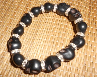 Zwarte schedelarmband van steen in neogotische stijl met kristallen afstandhouders en stenen schedels. Elegante zombie-sieraden