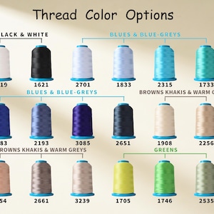 K&ouml;nnte beinhalten: Eine Farbkarte mit dem Titel Thread Color Options, die achtzehn Garnrollen in verschiedenen Farbt&ouml;nen zeigt. Die Kategorien umfassen Black & White, Blues & Blue-Greys, Browns Khakis & Warm Greys und Greens, jeweils mit einem Zahlencode.