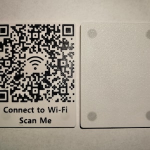 May include: Two white rectangular cards. One card features a black and white QR code with a Wi-Fi symbol and the text "Connect to Wi-Fi Scan Me." The other card is plain white with four gray dots.