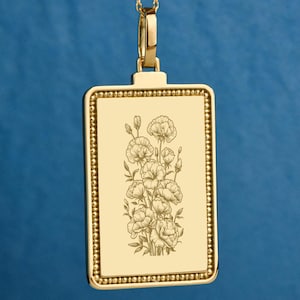 May include: Gold-colored rectangular pendant with a floral design. The pendant features a detailed engraving of flowers and is suspended from a delicate gold chain. The pendant has a beaded border and a simple bail.
