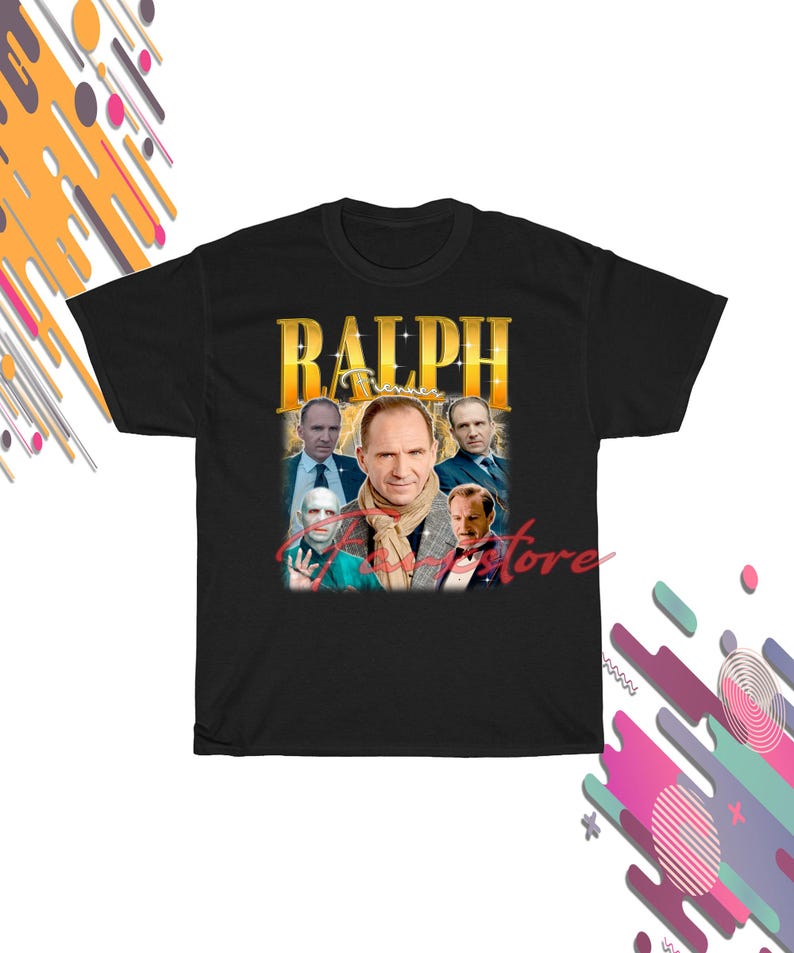 May include: Black t-shirt with a gold-toned graphic of Ralph Fiennes and the name "RALPH". The design incorporates several images of the actor in a vintage style. The shirt has a crew neck.